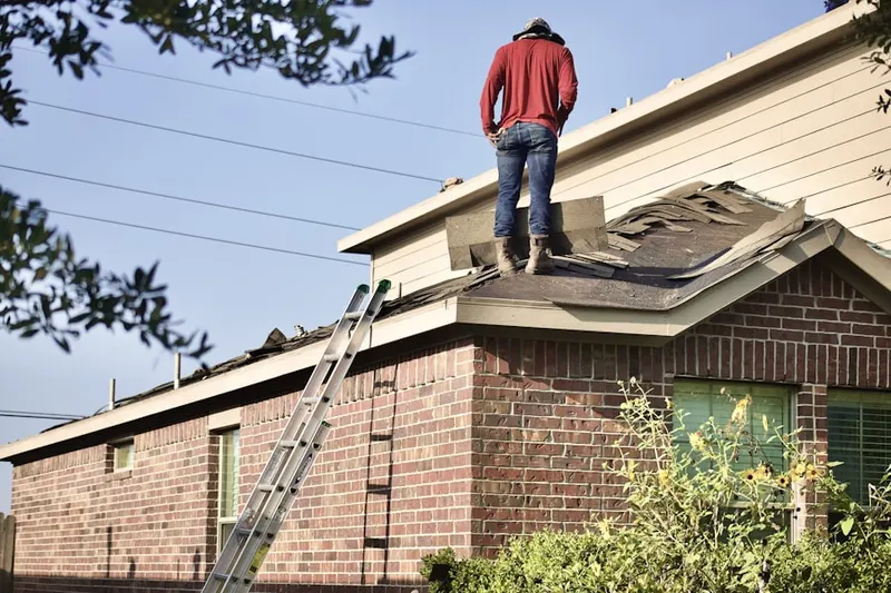 Professional roofer working on a residential roof in Sheldon